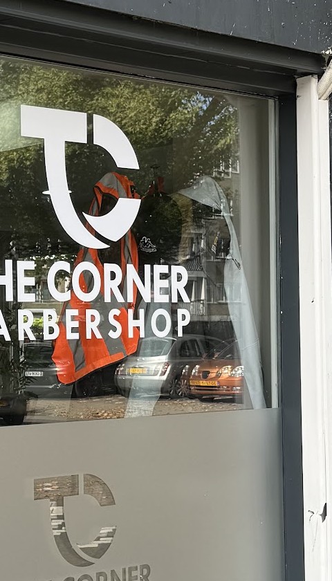 Het TC-logo met The Corner Barbershop op het raam van de zaak